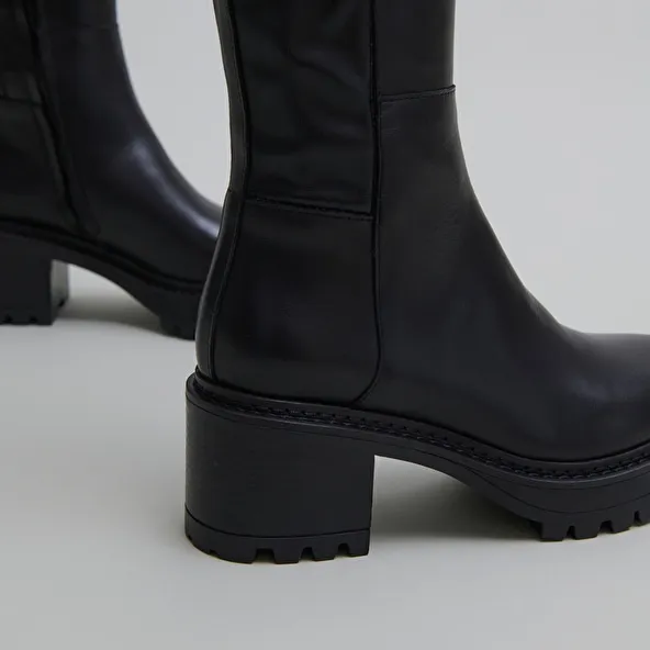 Boots with notched soles in leather and black stretch