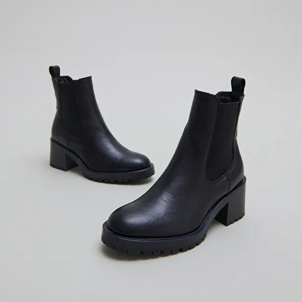 High boots with notched soles in black grained leather