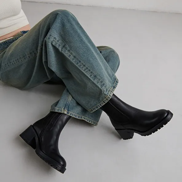 High boots with notched soles in black grained leather