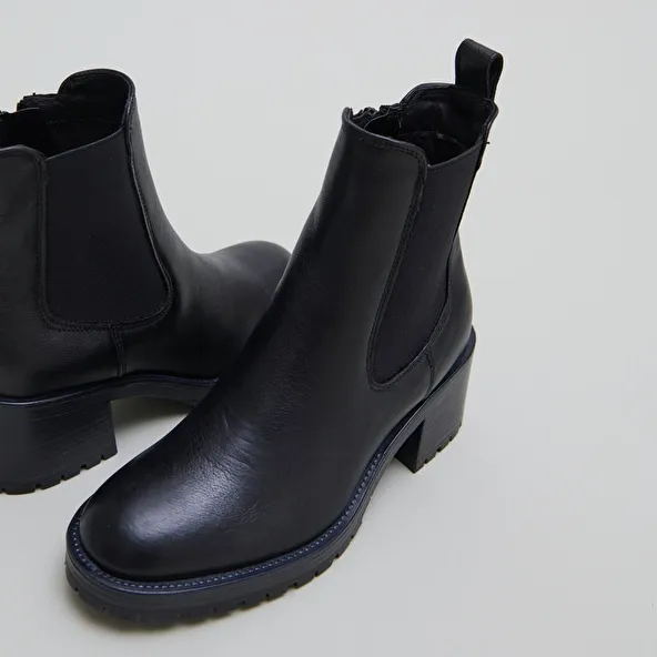 High boots with notched soles in black grained leather